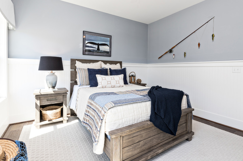 This is an example of a large coastal guest bedroom in Other with grey walls, medium hardwood flooring, no fireplace and brown floors.