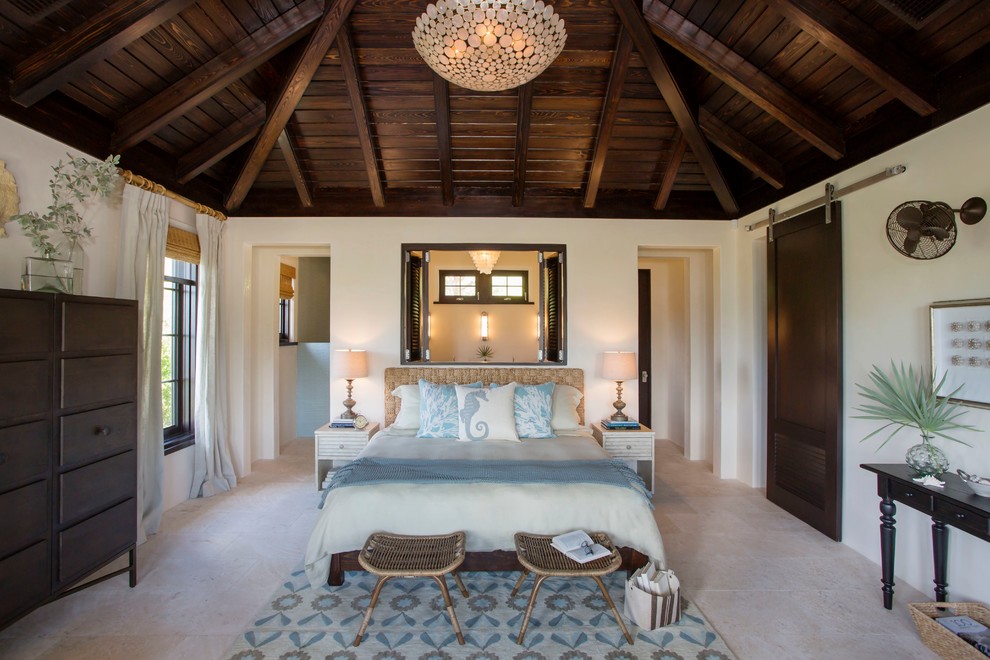 Immagine di una camera matrimoniale tropicale con pareti bianche e pavimento in travertino