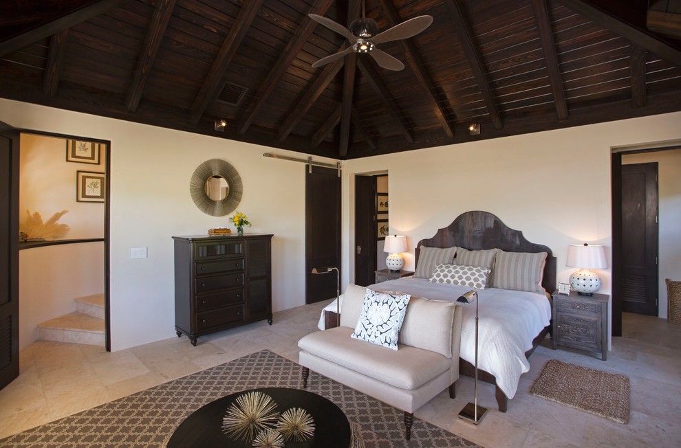 Imagen de habitación de invitados tropical con paredes blancas y suelo de travertino
