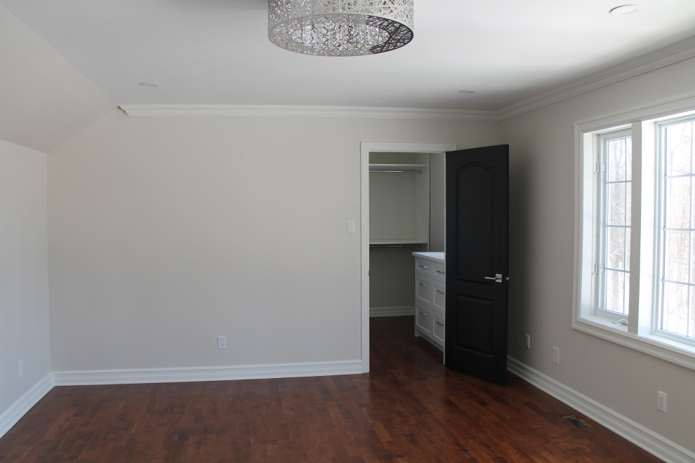 Design ideas for a large classic master bedroom in Montreal with grey walls and medium hardwood flooring.