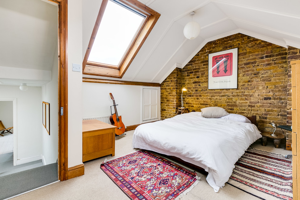 Medium sized country bedroom in London with white walls, carpet and beige floors.