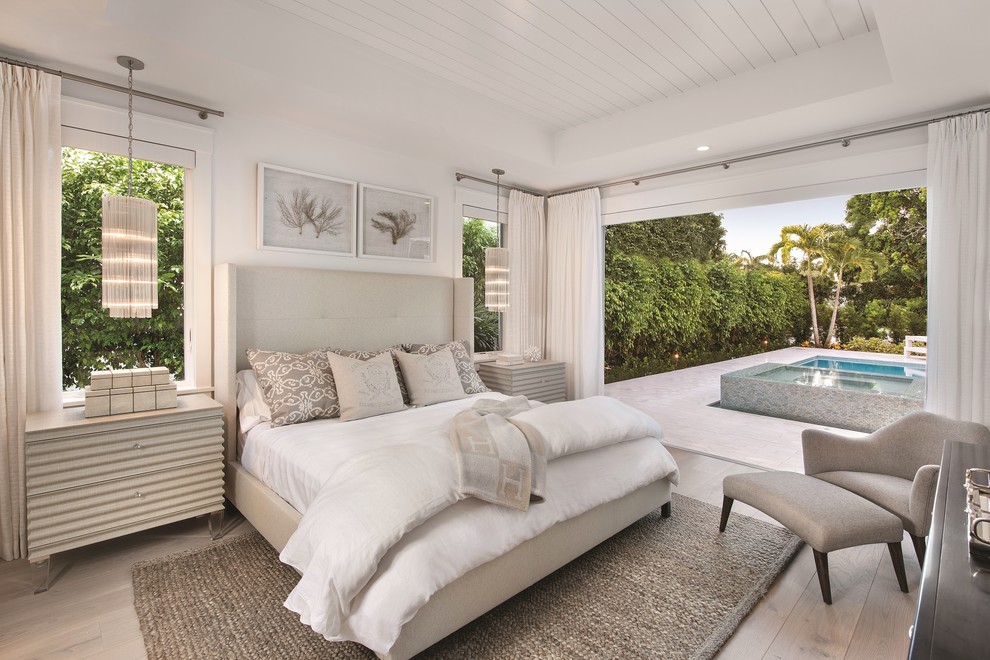 Bedroom - coastal master light wood floor bedroom idea in Miami with white walls