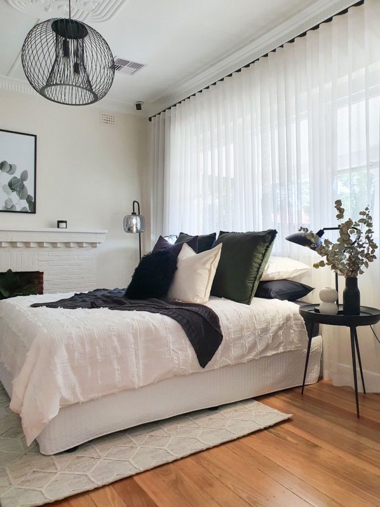 Ejemplo de dormitorio actual con paredes beige, suelo de madera en tonos medios y suelo marrón