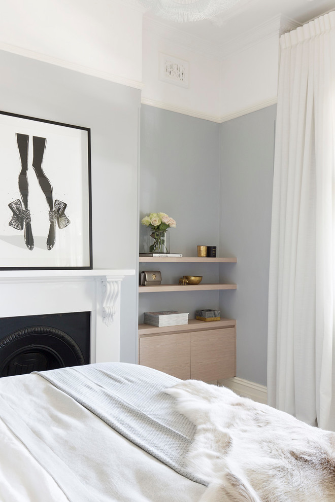 На фото: хозяйская спальня среднего размера в современном стиле с синими стенами, ковровым покрытием, стандартным камином, фасадом камина из штукатурки и бежевым полом с