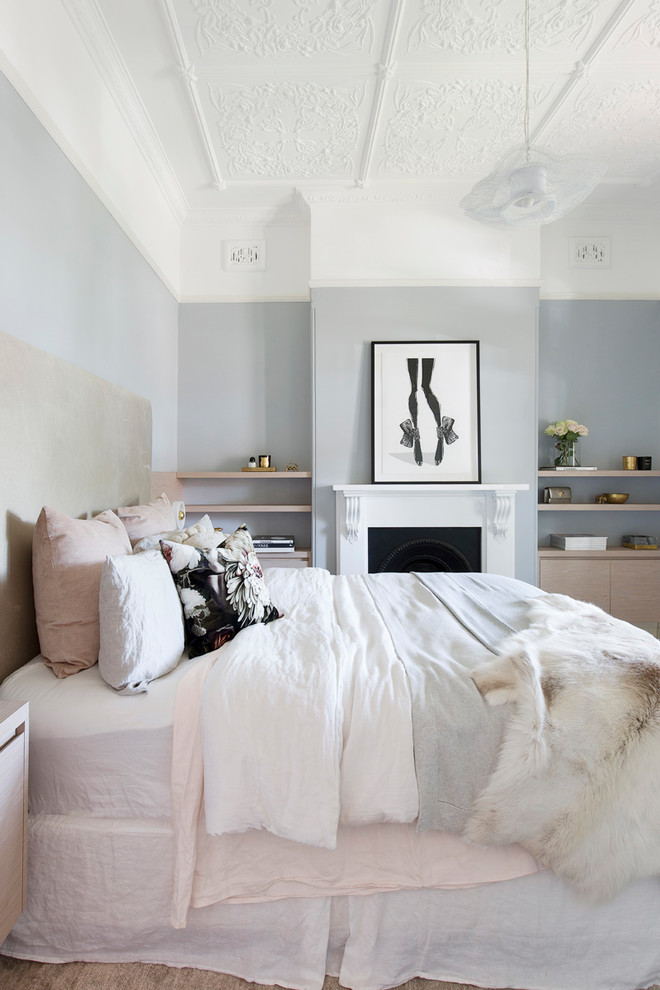 На фото: хозяйская спальня среднего размера в скандинавском стиле с синими стенами, ковровым покрытием, стандартным камином, фасадом камина из штукатурки и бежевым полом
