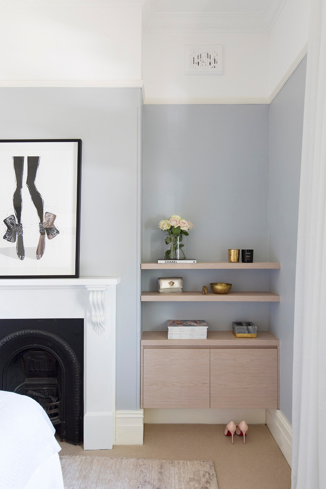 Idée de décoration pour une chambre design de taille moyenne avec un mur bleu, une cheminée standard, un manteau de cheminée en plâtre et un sol beige.