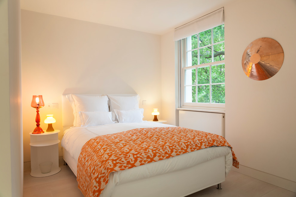Kleines Modernes Gästezimmer ohne Kamin mit weißer Wandfarbe und hellem Holzboden in London