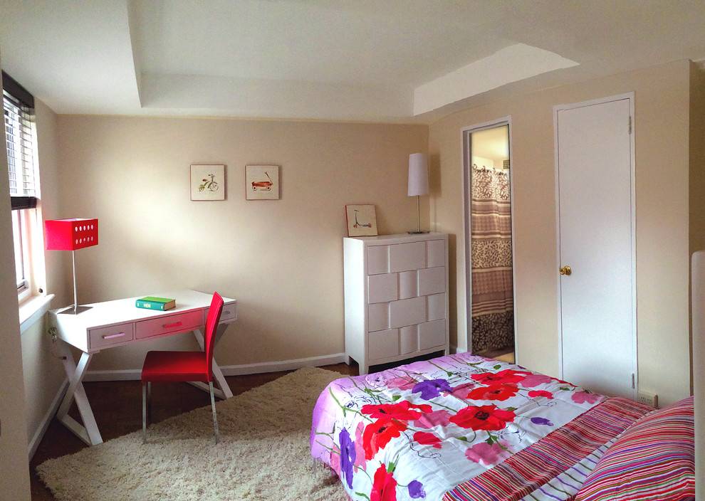 Modelo de habitación de invitados actual de tamaño medio sin chimenea con paredes beige, suelo de madera oscura y con escritorio
