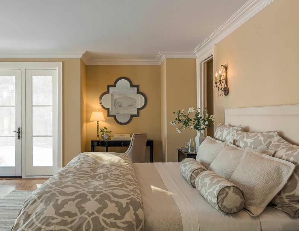 Aménagement d'une grande chambre classique avec un mur beige et parquet clair.