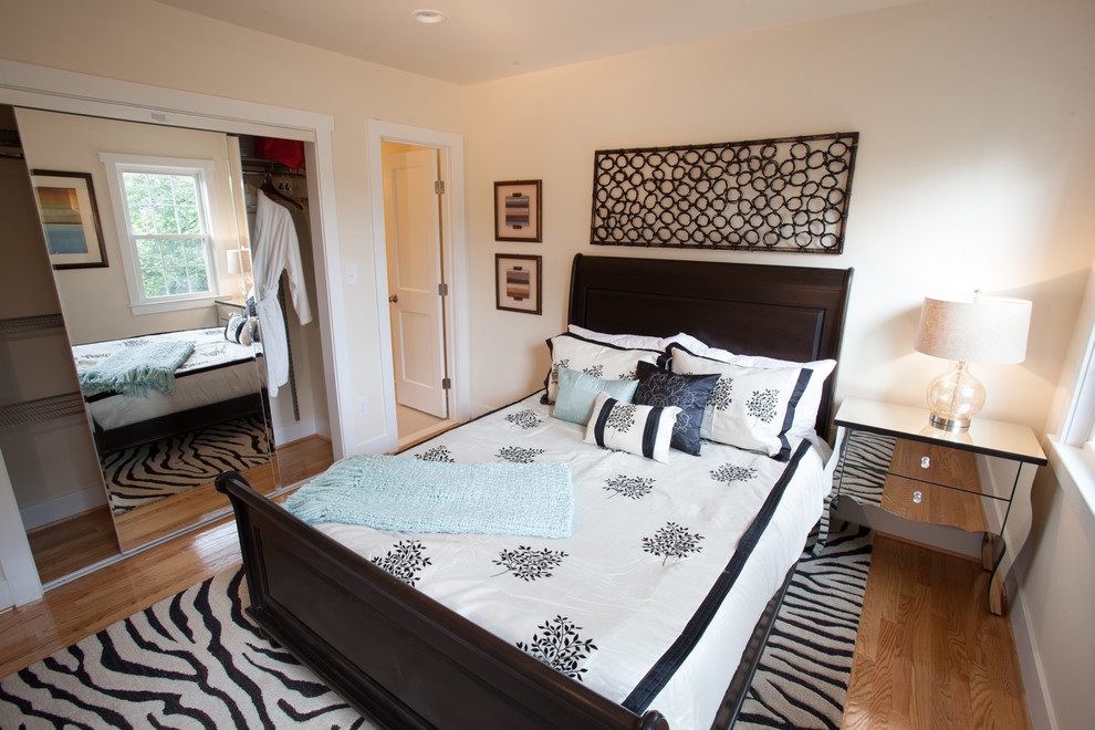 Modelo de dormitorio principal clásico renovado pequeño con paredes blancas y suelo de madera clara