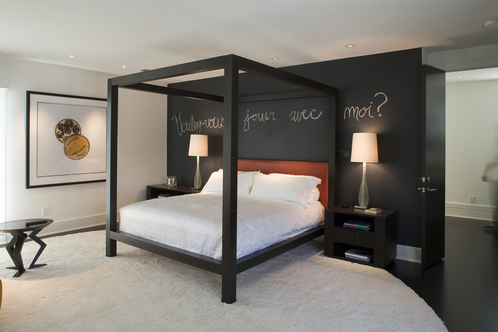 Imagen de dormitorio principal contemporáneo de tamaño medio sin chimenea con paredes negras y suelo de cemento