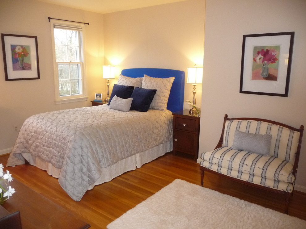 Cette photo montre une chambre d'amis tendance de taille moyenne avec un mur beige et un sol en bois brun.