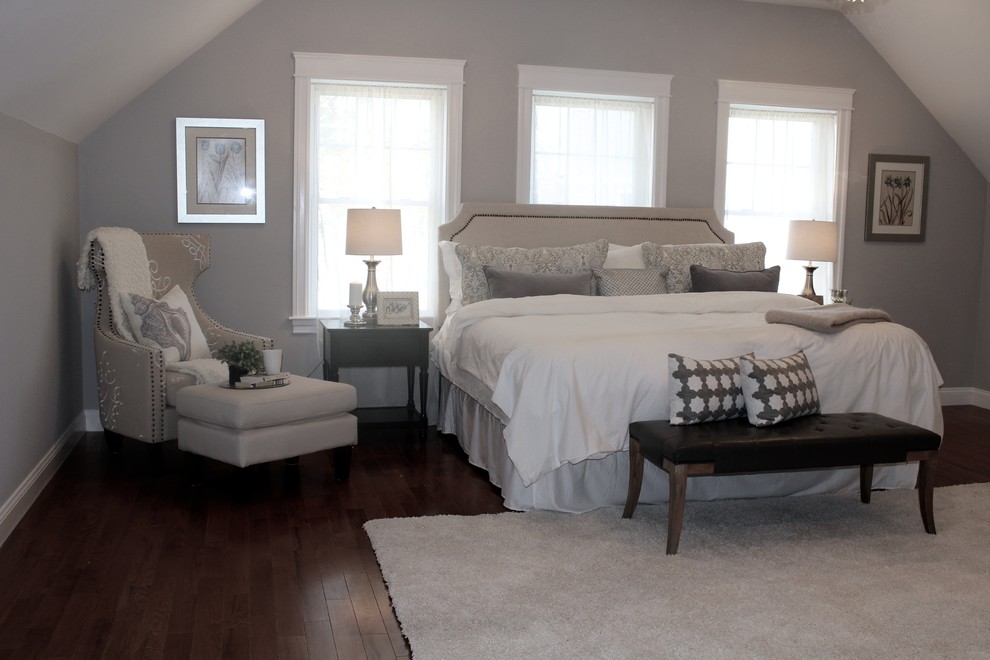 Ejemplo de dormitorio principal tradicional renovado grande sin chimenea con paredes grises y suelo de madera en tonos medios