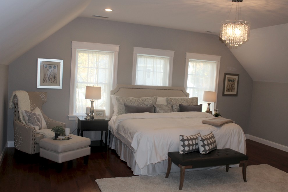 Imagen de dormitorio principal tradicional renovado grande sin chimenea con paredes grises y suelo de madera en tonos medios