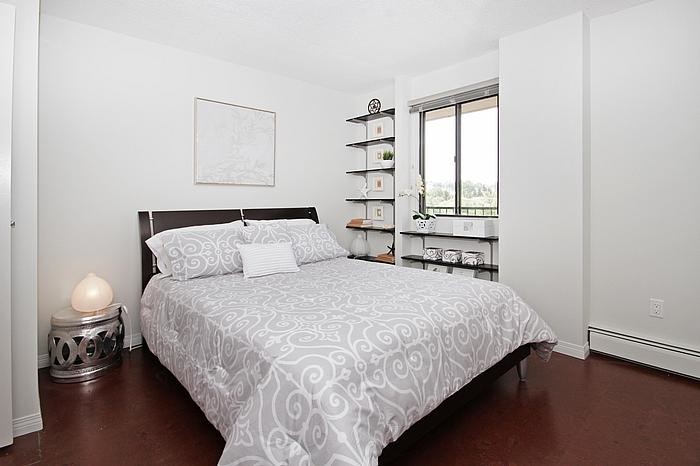 Modelo de dormitorio principal clásico renovado pequeño sin chimenea con paredes blancas y suelo de corcho