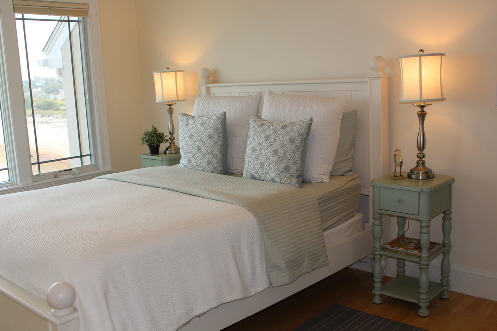 Foto de habitación de invitados costera de tamaño medio con paredes amarillas y suelo de madera en tonos medios