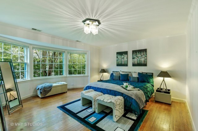 Réalisation d'une chambre parentale minimaliste de taille moyenne avec un mur blanc, parquet clair et un sol marron.