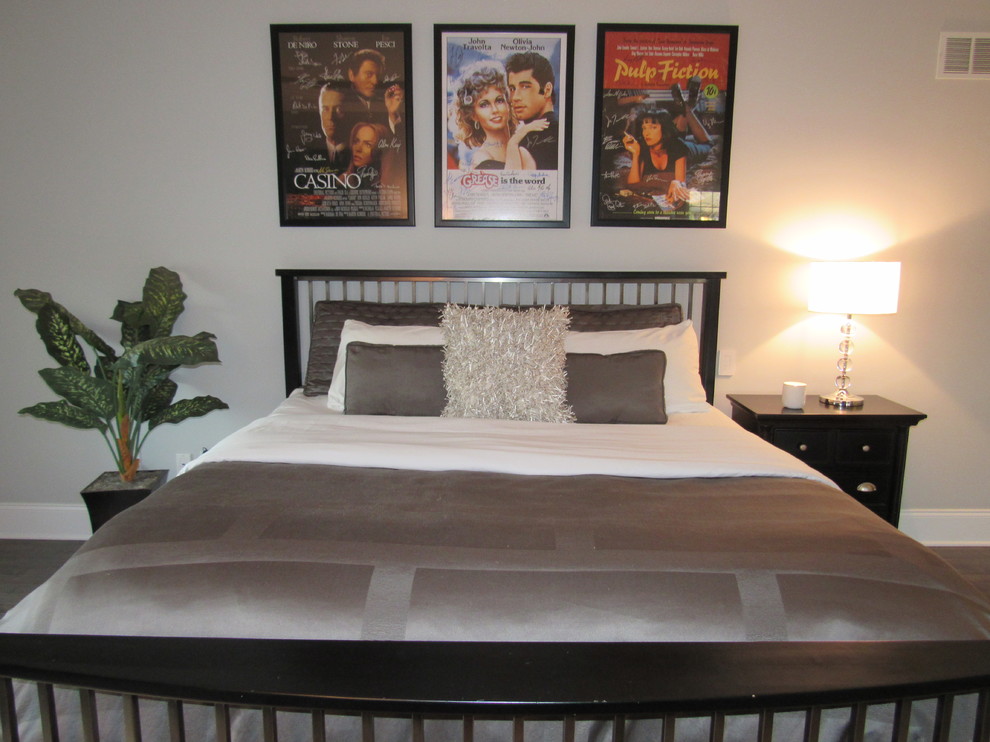 Modelo de dormitorio principal contemporáneo de tamaño medio sin chimenea con paredes grises y suelo de madera en tonos medios