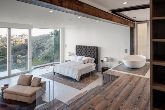 Ejemplo de dormitorio principal rural grande con paredes blancas y suelo de madera en tonos medios
