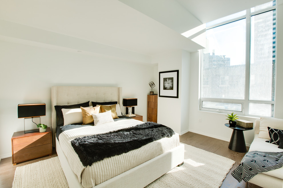 Imagen de dormitorio principal contemporáneo de tamaño medio con paredes blancas y suelo de madera en tonos medios