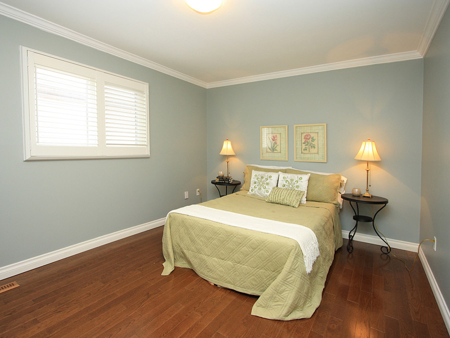 Идея дизайна: гостевая спальня среднего размера, (комната для гостей) в стиле фьюжн с зелеными стенами и паркетным полом среднего тона без камина