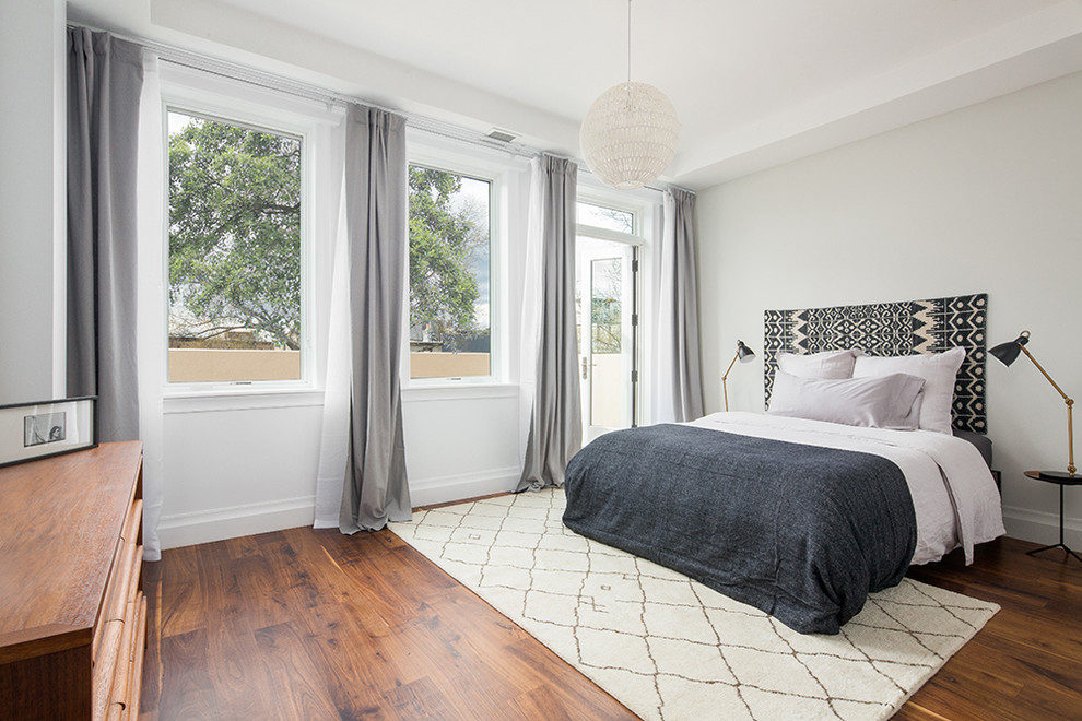 Modelo de habitación de invitados contemporánea de tamaño medio sin chimenea con paredes grises y suelo de madera oscura