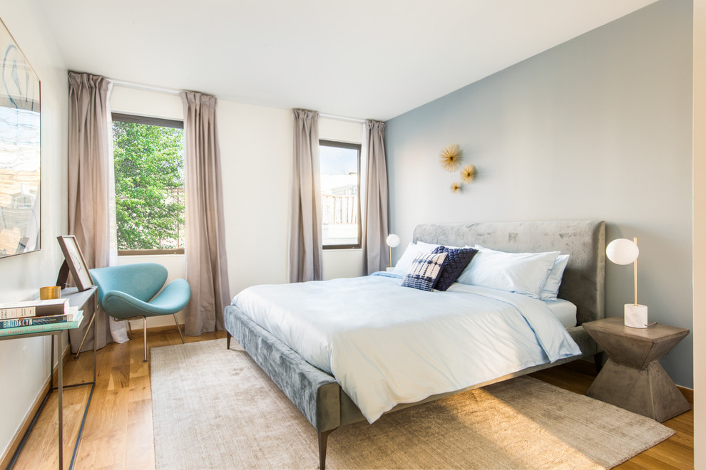 Idéer för ett mellanstort modernt sovrum, med blå väggar, ljust trägolv och beiget golv