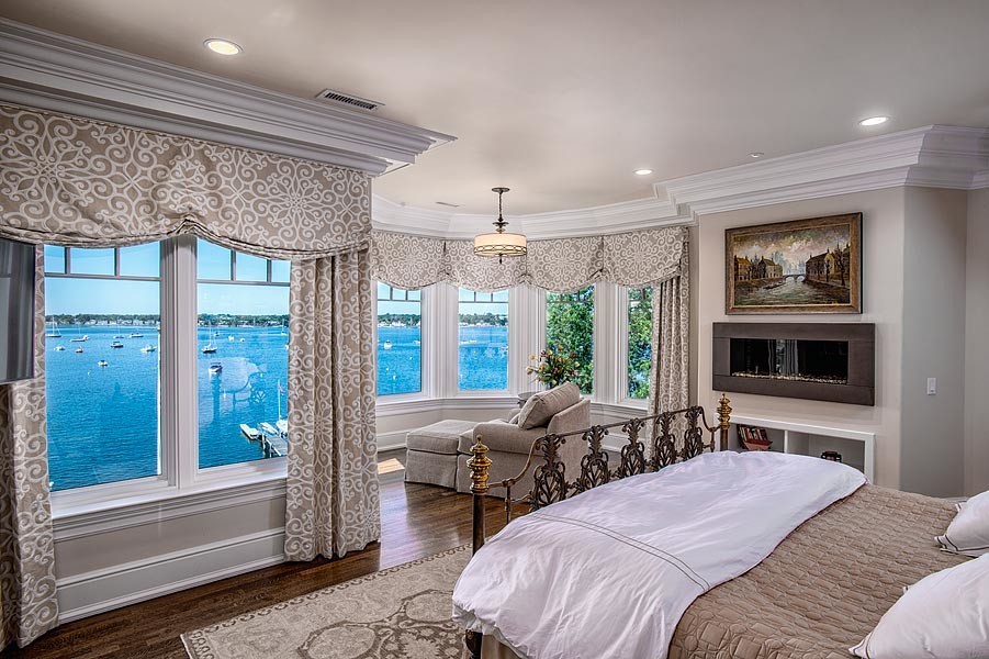 Großes Klassisches Hauptschlafzimmer mit beiger Wandfarbe, braunem Holzboden, Gaskamin, Kaminumrandung aus Metall und braunem Boden in New York