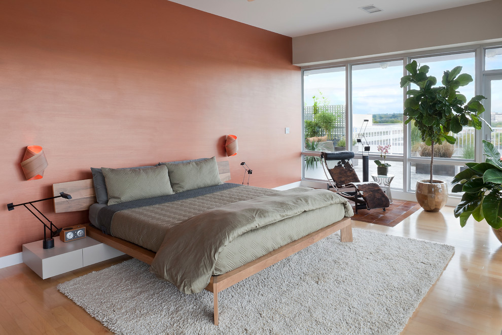 Design ideas for a large contemporary master and grey and pink bedroom in New York with pink walls, light hardwood flooring and no fireplace.