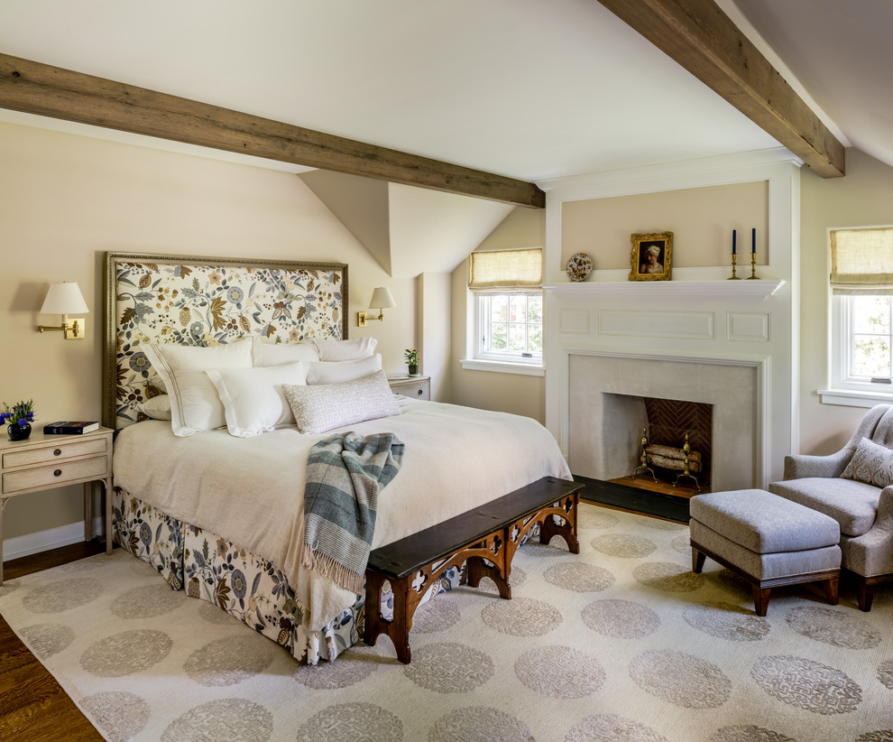 フィラデルフィアにある広いトラディショナルスタイルのおしゃれな主寝室 (ベージュの壁、無垢フローリング、標準型暖炉、漆喰の暖炉まわり、茶色い床)