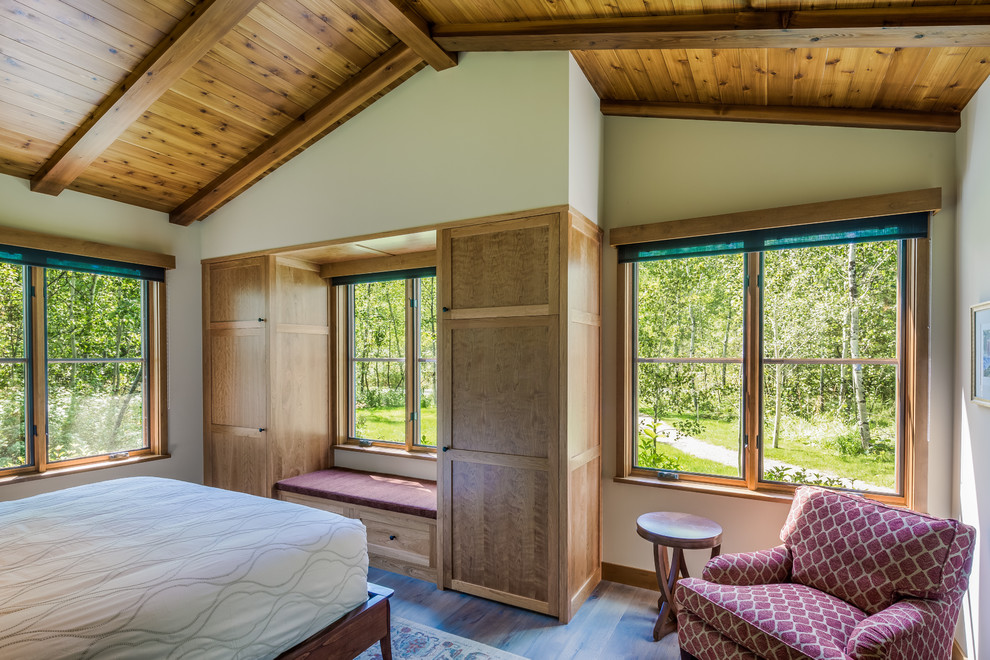 Foto de habitación de invitados rústica de tamaño medio con paredes beige y suelo de madera en tonos medios