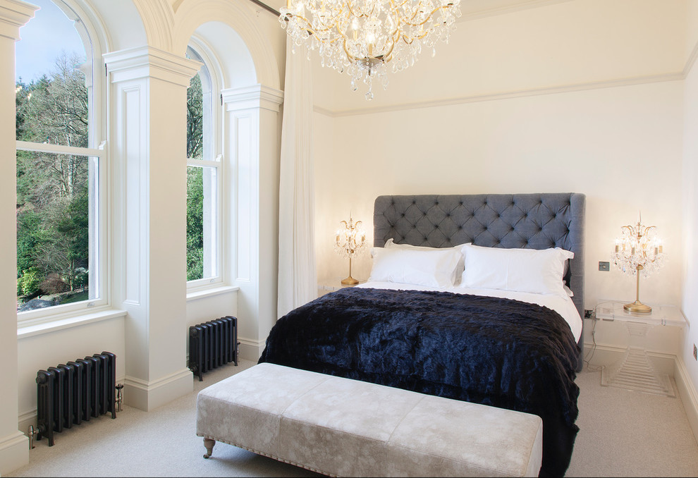 Large traditional bedroom in Other with white walls, carpet and grey floors.