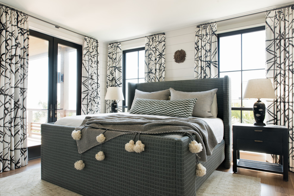Maritimes Schlafzimmer mit weißer Wandfarbe, braunem Holzboden und braunem Boden in Charleston
