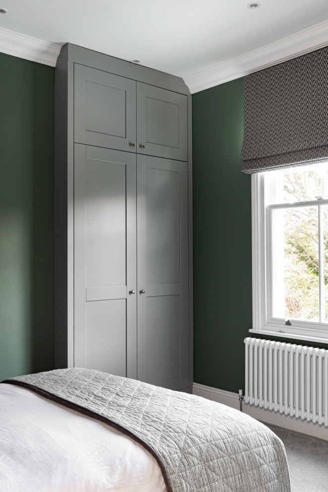 Example of a large transitional guest carpeted and gray floor bedroom design in London with green walls