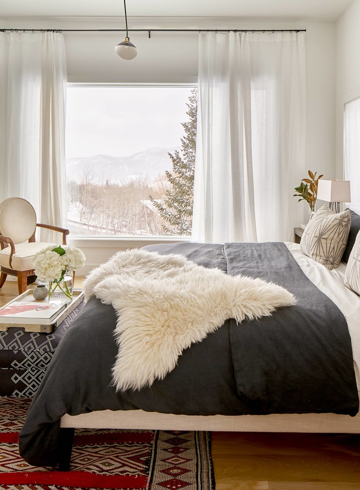 Großes Modernes Hauptschlafzimmer mit weißer Wandfarbe, braunem Holzboden und braunem Boden in Denver