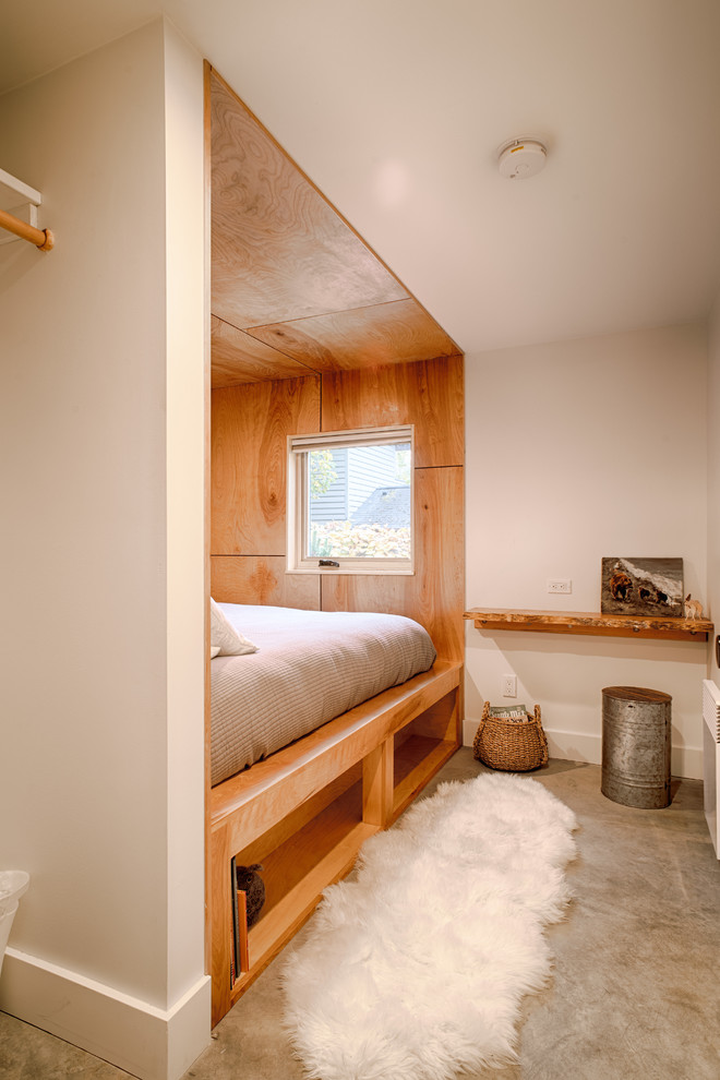 На фото: маленькая гостевая спальня (комната для гостей) в стиле модернизм с белыми стенами, бетонным полом и серым полом без камина для на участке и в саду