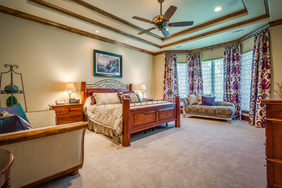 This is an example of a large traditional master bedroom in Dallas with beige walls, carpet and no fireplace.