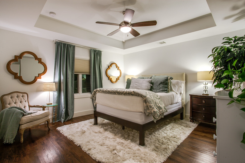 Design ideas for a traditional guest bedroom in Dallas with white walls, medium hardwood flooring and no fireplace.