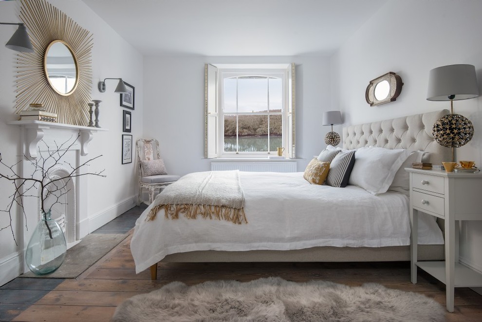 Idée de décoration pour une chambre tradition avec un mur blanc, un sol en bois brun, une cheminée standard et un sol marron.