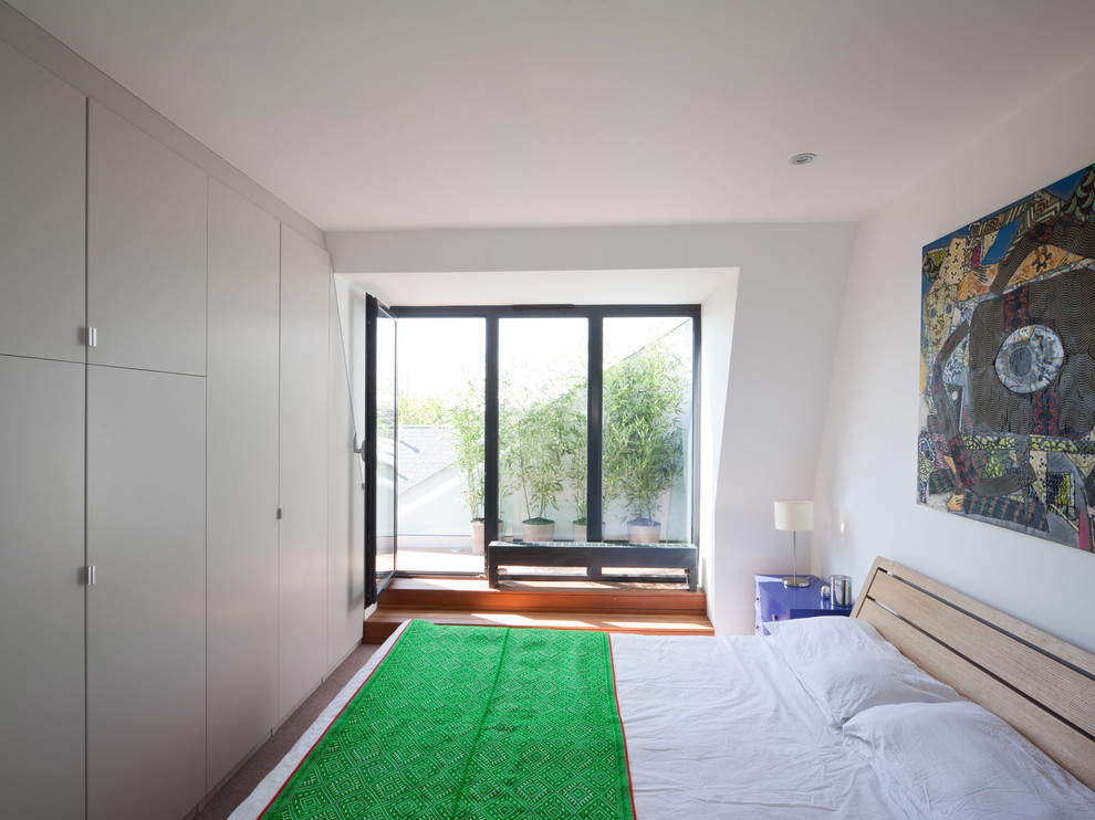 Photo of a medium sized contemporary bedroom in London with white walls, carpet and no fireplace.