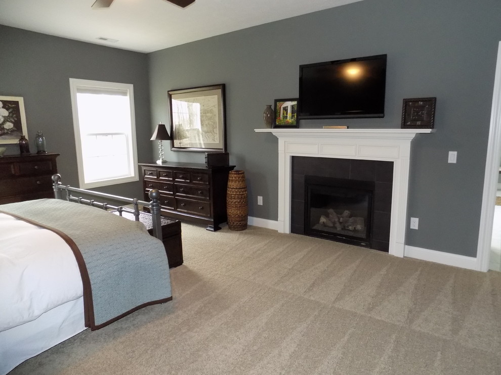 Example of a large trendy master carpeted bedroom design in Columbus with gray walls, a standard fireplace and a tile fireplace