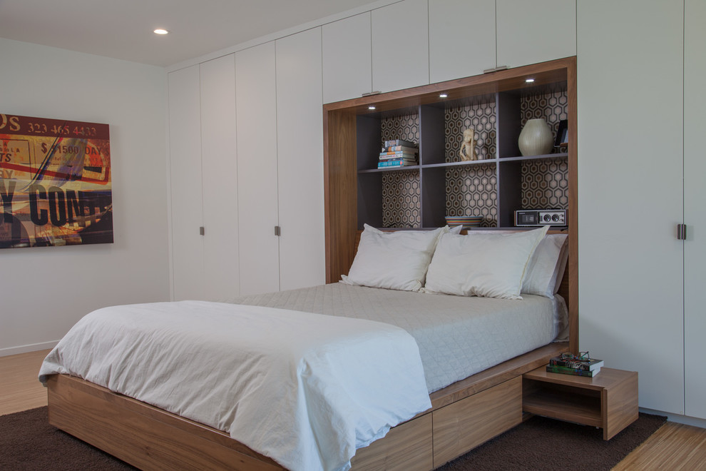 Retro master bedroom in Los Angeles with white walls and light hardwood flooring.