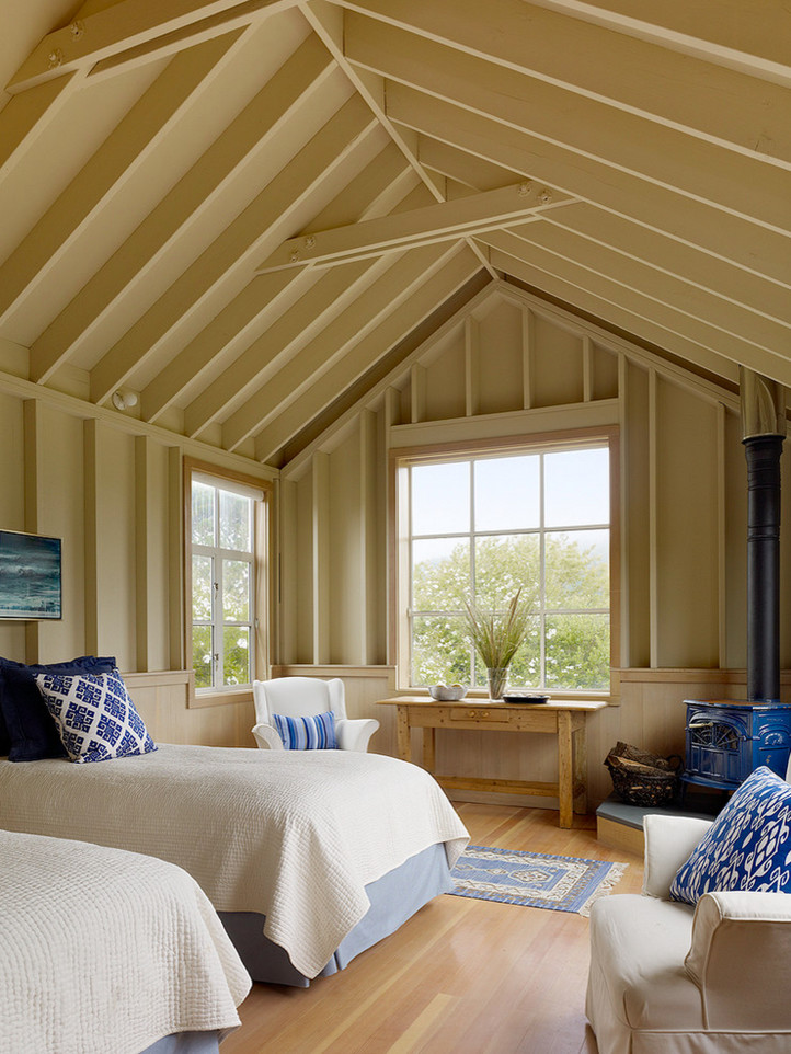 Imagen de habitación de invitados marinera pequeña con paredes beige, suelo de madera clara y chimenea de esquina