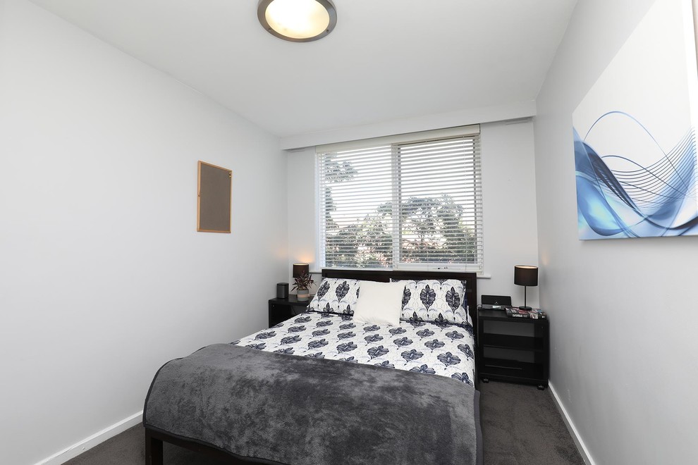 Diseño de habitación de invitados actual pequeña sin chimenea con paredes blancas, moqueta y suelo gris