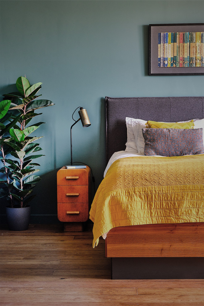 Modelo de dormitorio principal vintage grande con paredes azules, suelo de madera oscura y suelo marrón