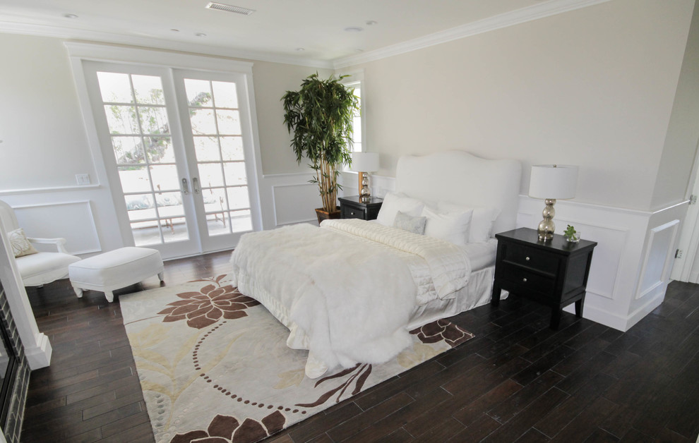 Immagine di una camera matrimoniale minimalista con pareti beige e pavimento in laminato