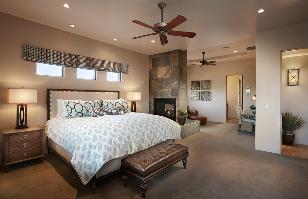 フェニックスにある広いサンタフェスタイルのおしゃれな主寝室 (ベージュの壁、カーペット敷き、両方向型暖炉) のインテリア