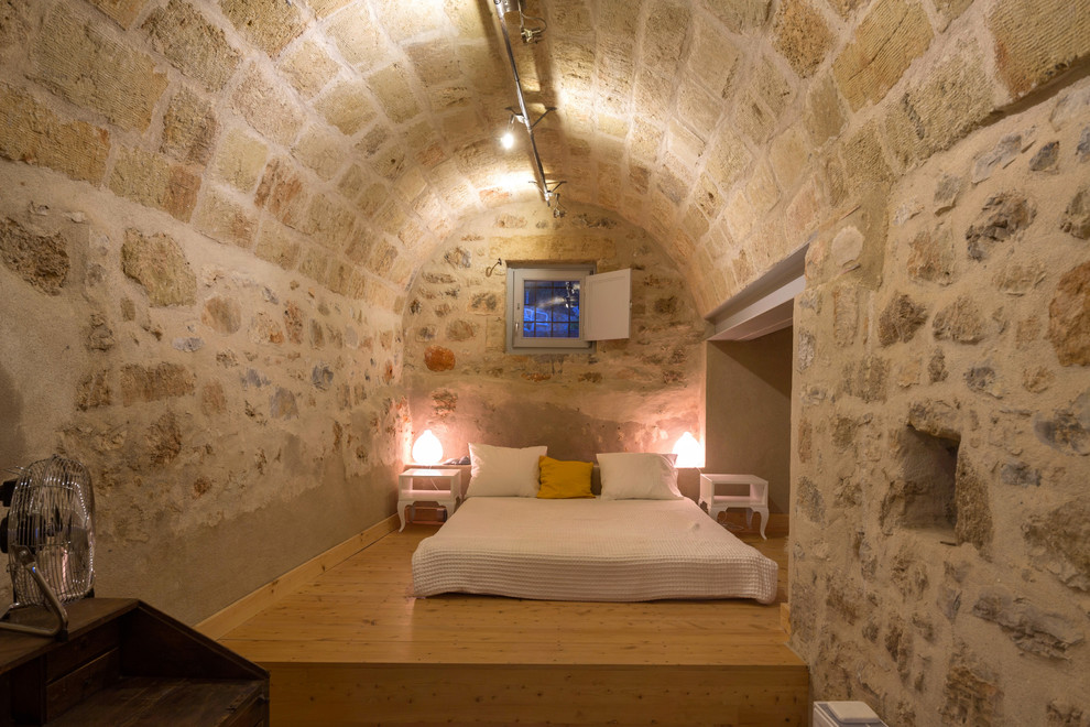 Imagen de dormitorio mediterráneo con suelo de madera clara