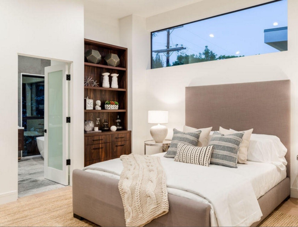 Ejemplo de dormitorio principal actual de tamaño medio con paredes blancas y suelo de madera en tonos medios