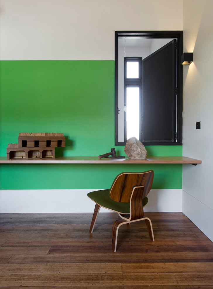 Ejemplo de dormitorio contemporáneo con paredes verdes y suelo de madera en tonos medios